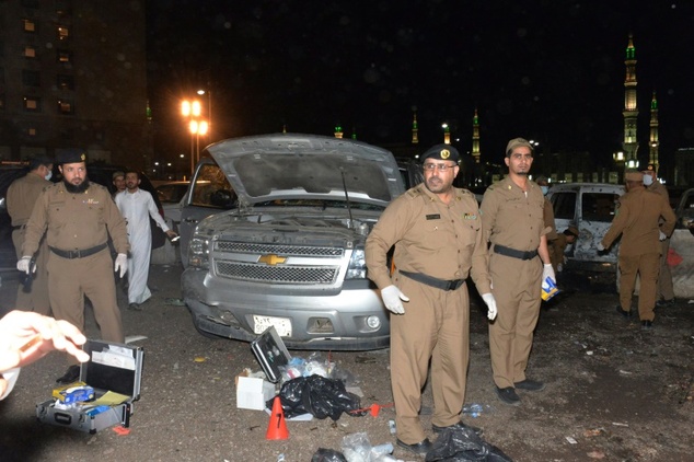 Saudi security personel gather at the site of the suicide attack near the security headquarters of the Prophet's Mosque in Medina City