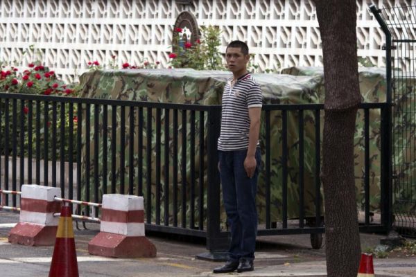 A plainclothes security person stands on duty outside