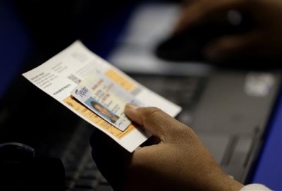 A person holds a driver's license in Austin on Feb. 26 2014. The scene was common during elections that year as the state's voting ID requirement was in effect. On Wednesday a federal appeals court ruled that it violates the Voting Rights Act. AP