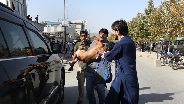 Afghans carry a boy who was injured in a deadly explosion that struck a protest march by ethnic Hazaras in Kabul Afghanistan Saturday