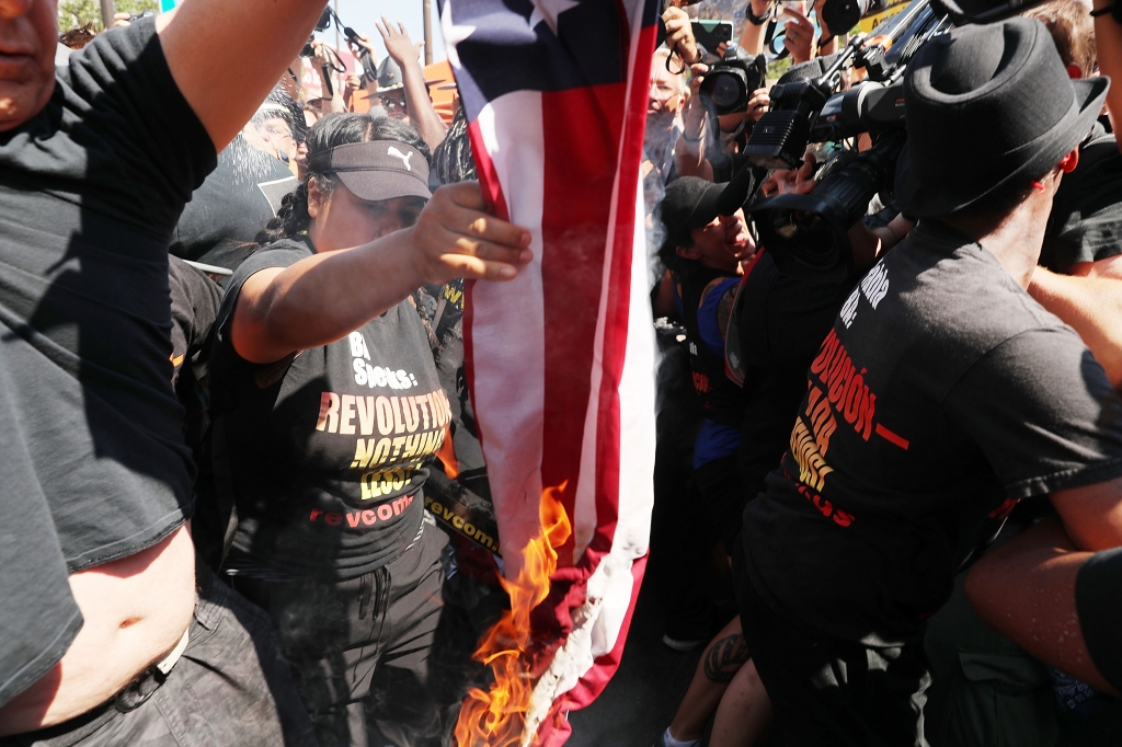 CLEVELAND OH- JULY 20 A group tries to burn an American Flag as police move in near the sight of the Republican National Convention in downtown Cleveland on the third day of the convention