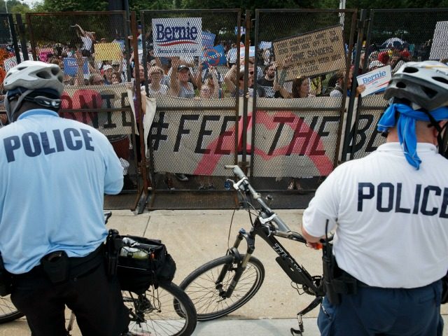 People protest through a security fence outside of the Wells Fargo Center venue of the 2016 Democratic National Convention during march holding signs in support of former Democratic presidential candidate Bernie Sanders during a protest outside the DNC