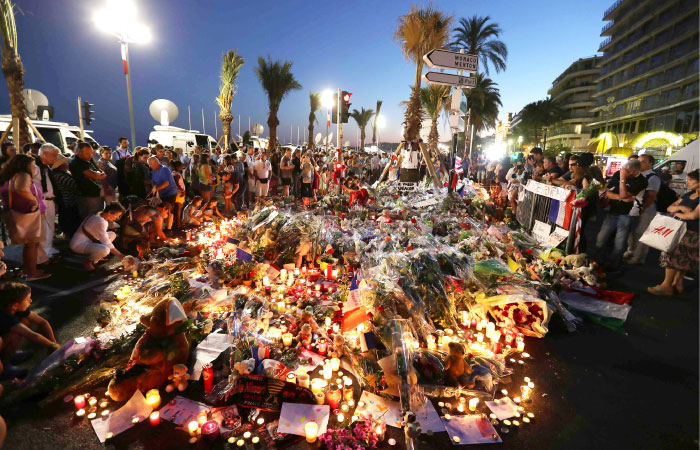 Crowds gather at a make-shift memorial for victims of the deadly Bastille Day attack on the Promenade des Anglais in Nice France on Saturday. — AFP