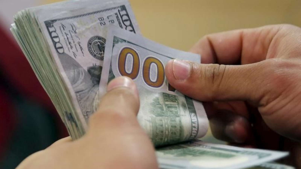 A customer counts his U.S. dollar money in a bank in Cairo Egypt