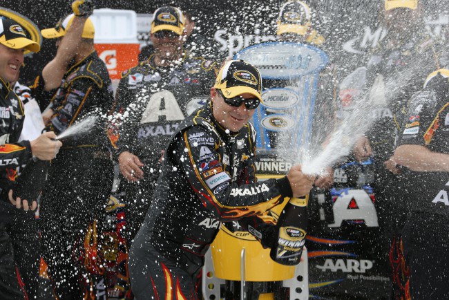 Jeff Gordon sprays champagne after his victory in the NASCAR Sprint Cup Series Pure Michigan 400 auto race at Michigan International Speedway in Brooklyn Mich. Sunday Aug. 17 2014