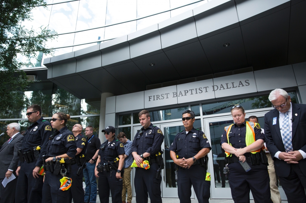 Police officers join parishioners of First Baptist Church in Dallas Texas as they gather on Sunday to pray for victims after 25-year-old black army veteran Micah Johnson used a high-power rifle to kill five police officers and wound seven in a sniper