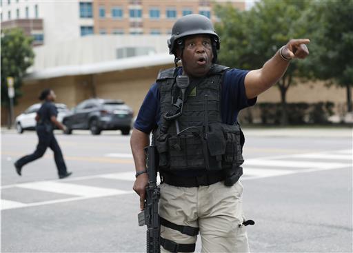 A Dallas police officer helps tighten security at their headquarters after receiving an anonymous threat against law enforcement across the city Saturday