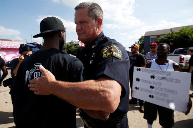 A Dallas police officer hugs a man following a prayer circle after a Black Lives Matter protest following the multiple police shootings in Dallas Texas U.S