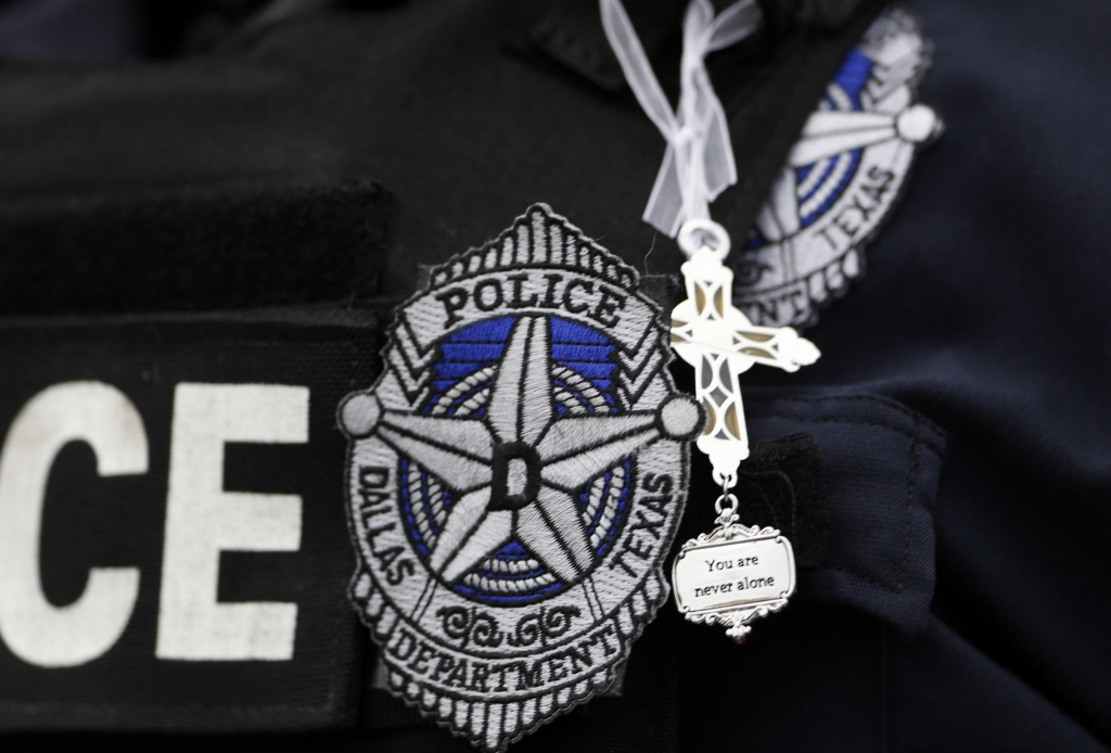 Dallas Police Sr. Corp. Kimberly Howard wears a cross given to her earlier in the day by a random well-wisher outside their headquarters in Dallas on Saturday