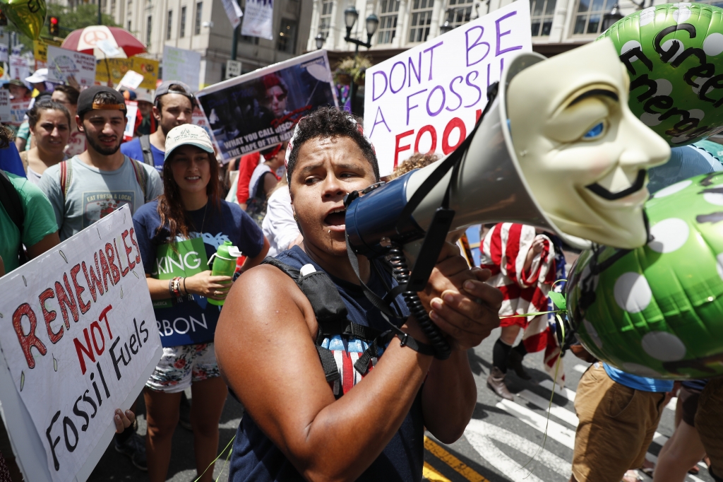 A protestor chants through a megaphone as he marches during a demonstration in downtown on Sunday