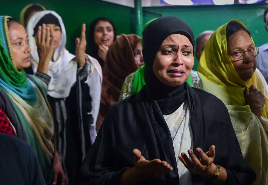 Relatives and friends of two victims of the attack mourn their deaths during a funeral in Dhaka