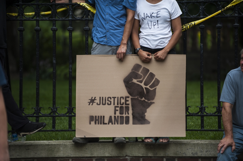 ST. PAUL MN- JULY 07 A couple hold a sign protesting the killing of Philando Castile outside the Governor's Mansion