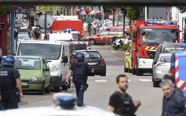 Police and rescue workers stand at the scene after two assailants had taken five people hostage in the church at Saint Etienne-du-Rouvray near Rouen in Normandy France