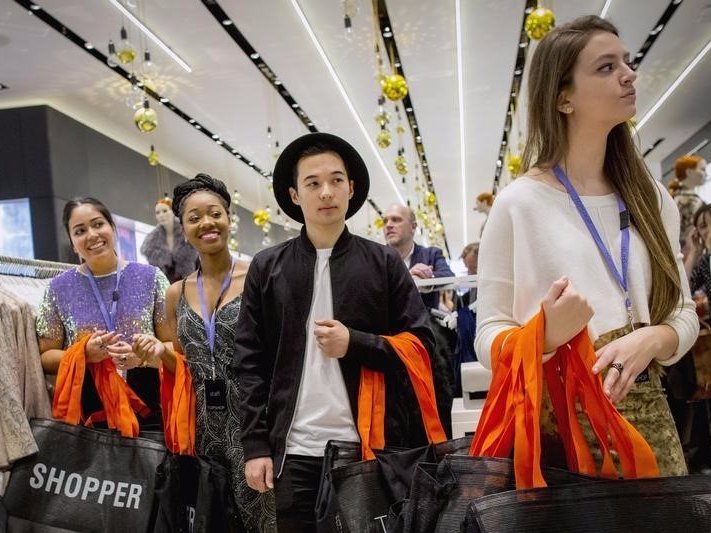 Employees wait to greet shoppers during British clothing retailer Topshop's grand opening of the chain's New York flagship store