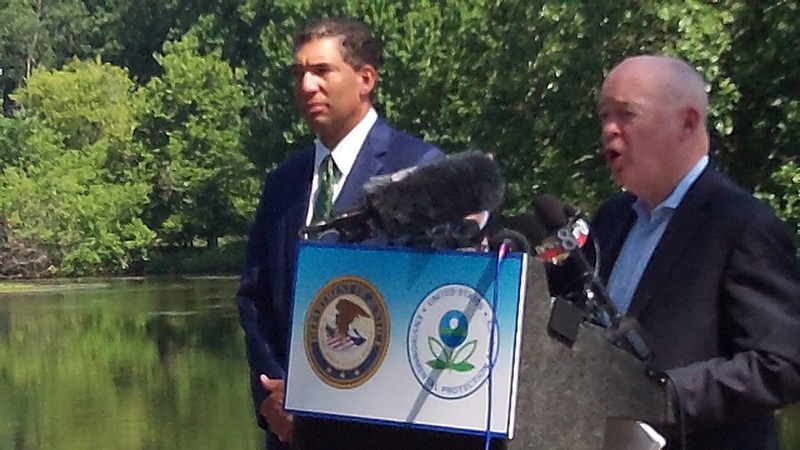 Caption U.S. Attorney for West Michigan Patrick Miles and U.S. Assistant Attorney General John Cruden announce the details of the settlement with Enbridge Energy. They set up their podium with the river as a backdrop. While they were critical of the pipe