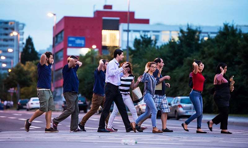 Evacuated people from the shopping mall walk with their hands up in Munich on July 22 following a shooting earlier.— AFP