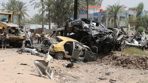 Iraqis inspect the damage at the site of a suicide bomb attack at the entrance to the town of Khales 80 kms northeast of Baghdad