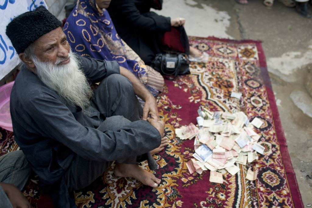 FILE- Pakistan's humanitarian leader Abdul Sattar Edhi collects donations at a roadside spot in Peshawar Pakistan Aug. 2 2010