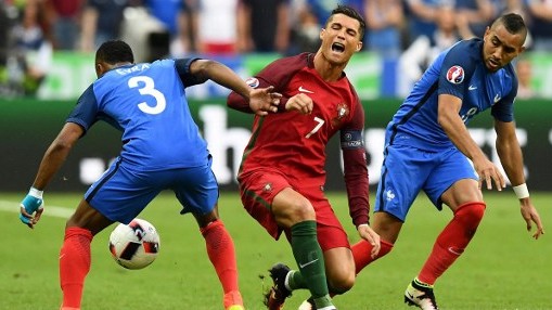 France's forward Dimitri Payet looks on as Portugal's forward Cristiano Ronaldo falls onto the pitch during the Euro 2016 final football match between France and Portugal at the Stade de France in Saint-Denis north of Paris