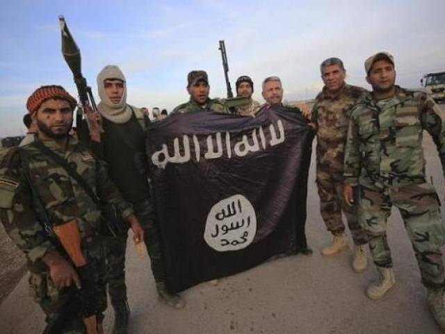 Fighters pose with an Islamic State flag