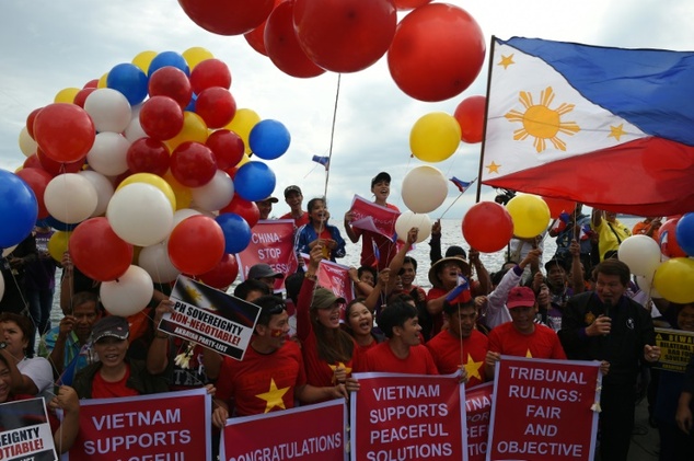 Filipino activists and Vietnamese nationals celebrate on Roxas Boulevard in Manila