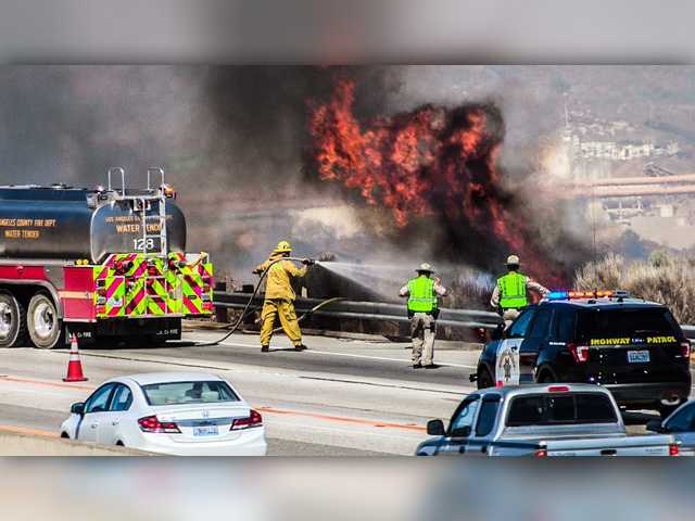 Firefighters spray flames near Highway 14 in Canyon Country. Signal