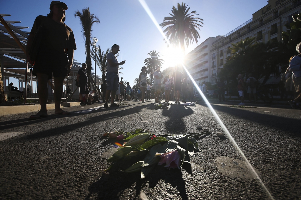 People lay flowers at the site of a deadly truck attack on the famed Promenade des Anglais in Nice southern France Saturday