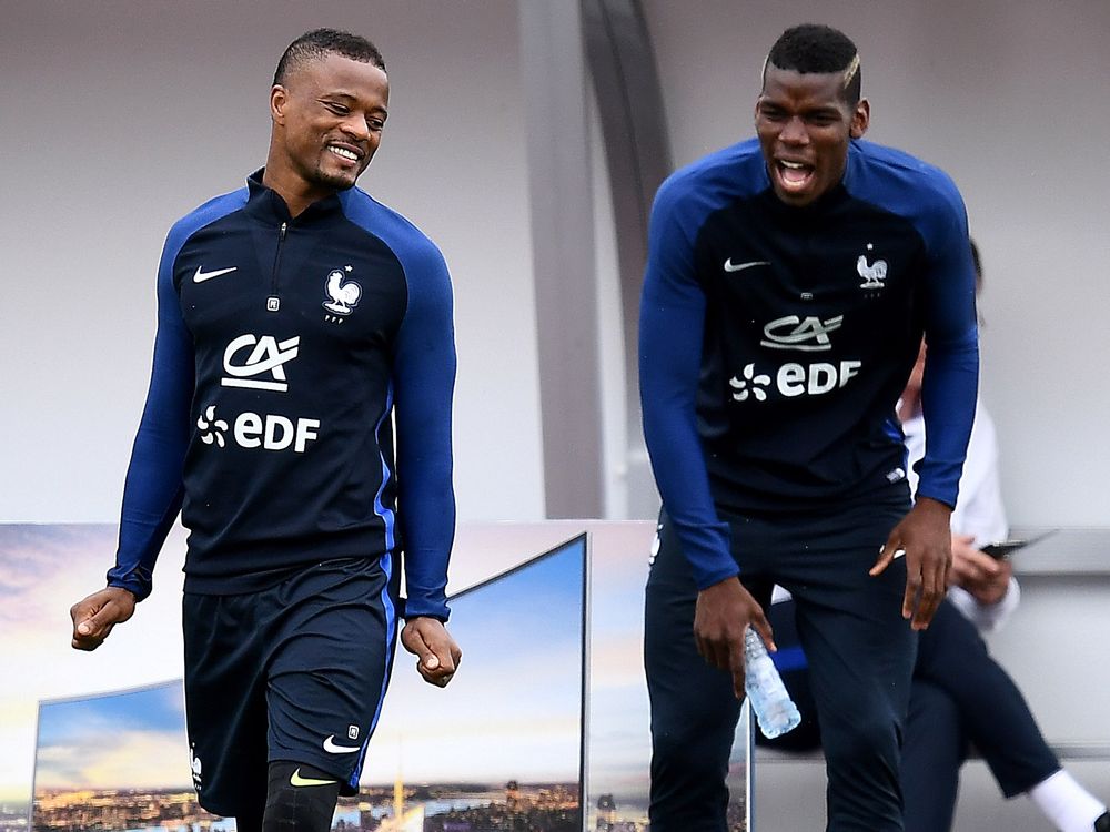 France's midfielder Paul Pogba jokes with France's defender Patrice Evra during a training sessiosn in Clairefontaine en Yvelines