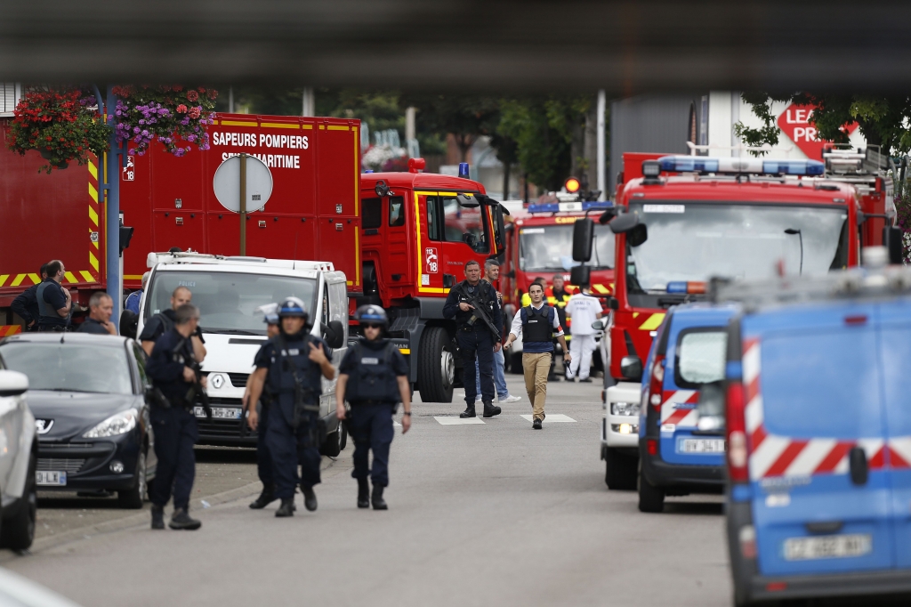 French police officers and firemen arrive at the scene of a hostage-taking at a church in Saint-Etienne-du-Rouvray northern France on July 26 that left a priest dead