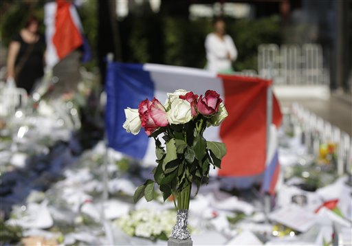 Floral and papers tributes are laid with a French flag near the scene of a truck attack in Nice southern France Saturday