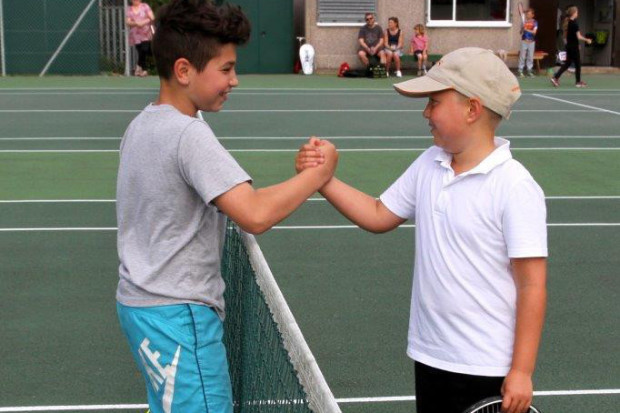 Friends Tyler Nasser and Thomas Shepherd shaking hands after a friendly tennis workout at the junior coaching session