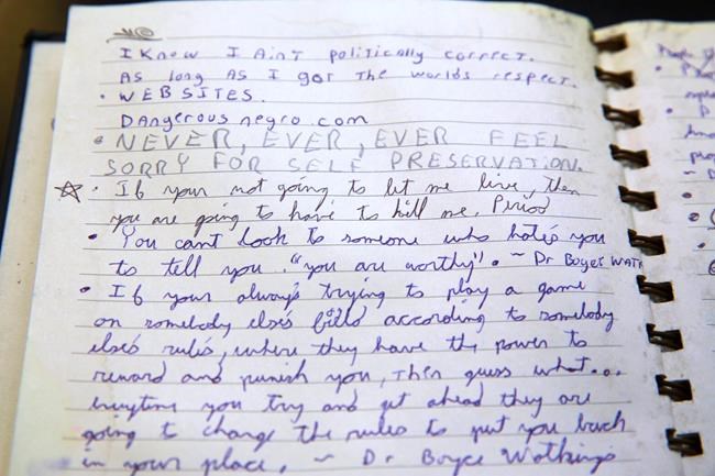 A portion of the diaries of Gavin Long provided by his mother Corine Woodley are seen during an interview with PBS talk show host Tavis Smiley in Los Angeles Thursday