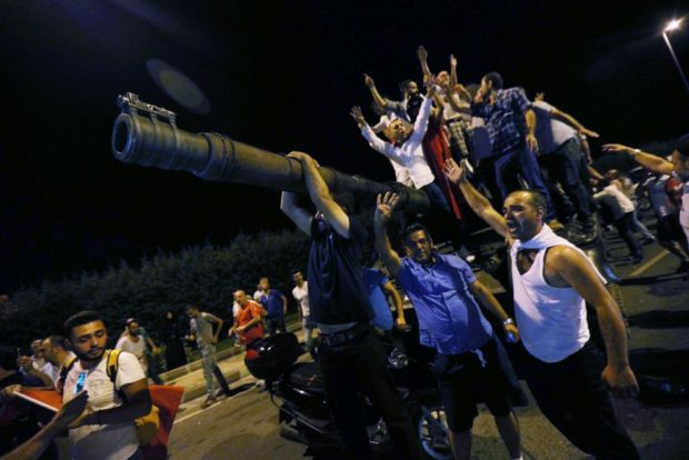 People stand on a Turkish army tank at Ataturk airport in Istanbul Turkey