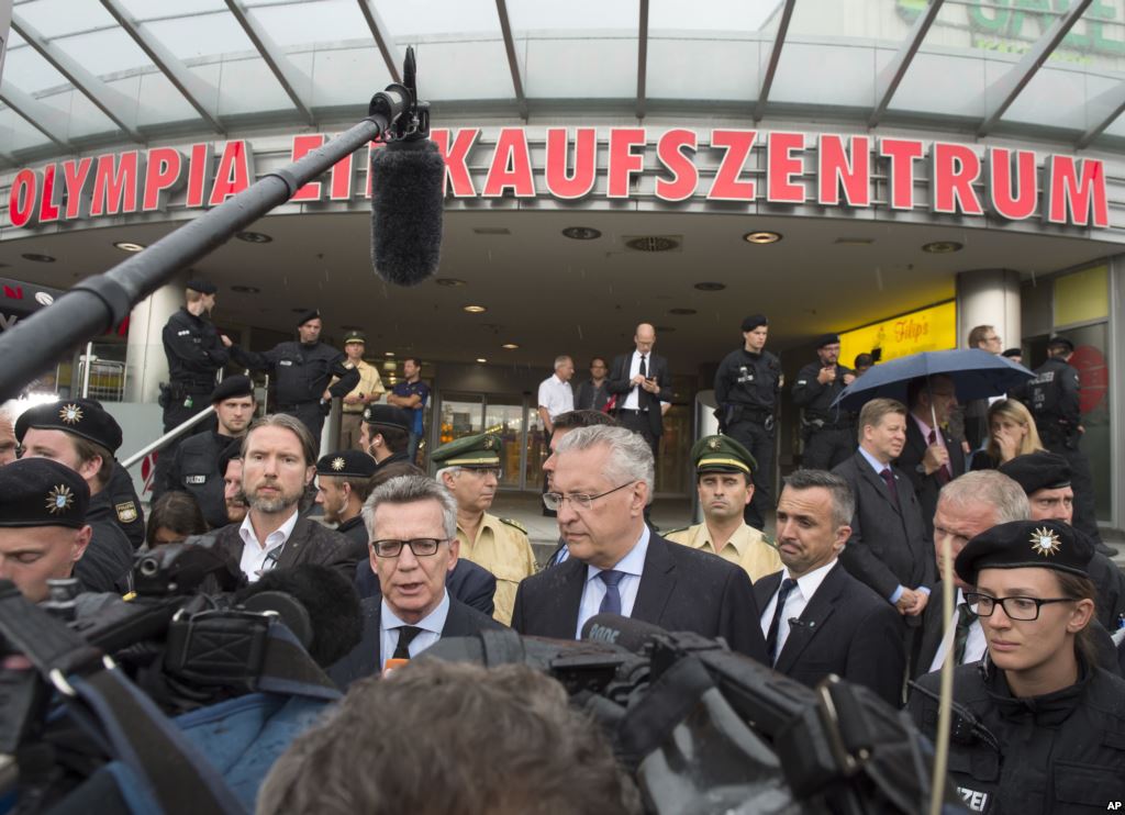 German Interior Minister Thomas de Maiziere left and Bavaria's Interior Minister Joachim Herrmann right give a media conference in front of the Olympia shopping center where a shooting took place leaving nine people dead the day before in Munich