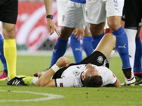 FILE- Germany's Mario Gomez lies injured on the pitch during the Euro 2016 quarterfinal soccer match between Germany and Italy at the Nouveau Stade in Bordeaux France Saturday