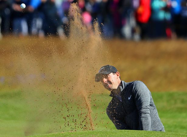 Rory Mc Ilroy plays his third shot from a bunker on the first hole