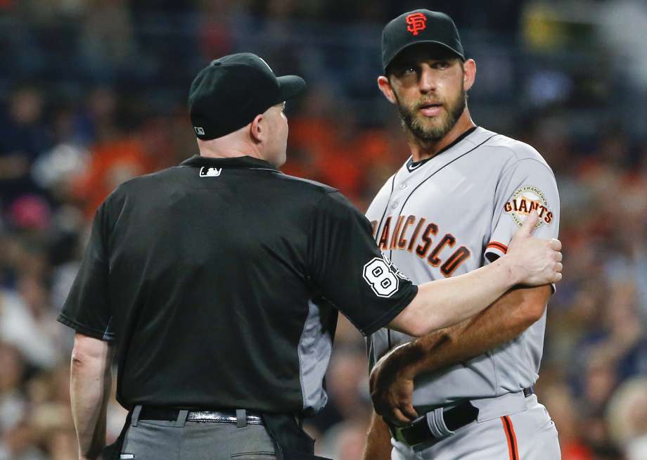 Home plate umpire Mike Estabrook puts a hand on the warm of San Francisco Giants pitcher Madison Bumgarner after the top half of the fifth inning of the Giants baseball game against the San Diego Padres on Friday