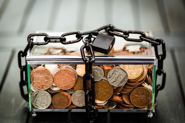 Glass box of money coins with padlock and chain