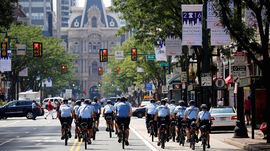 Police ride bicycles down Market Street toward City Hall ahead of the Democratic National Convention in Philadelphia