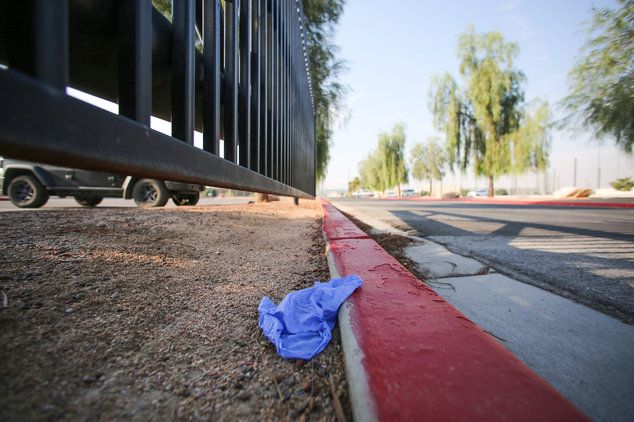 A medical glove lies discarded on a curb at Big League Dreams park near where police say a shooting erupted when a man in a vehicle attempted to rob a group