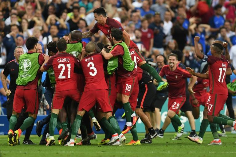 Portugal's forward Eder celebrates with teammates after he scored during the Euro 2016 final football match between Portugal and France at the Stade de France in Saint-Denis north of Paris