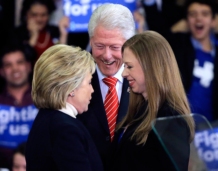 Democratic presidential candidate Hillary Clinton huddles with her husband former President Bill Clinton and daughter Chelsea at her New Hampshire presidential primary campaign rally in Hooksett N.H