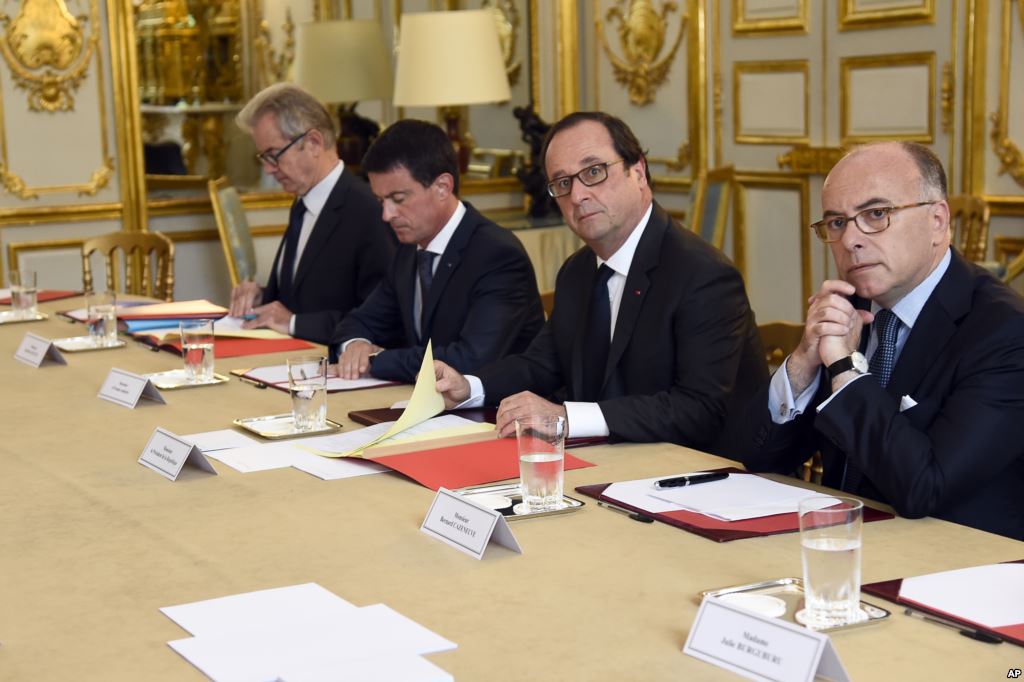 French President Francois Hollande flanked by his Interior Minister Bernard Cazeneuve right and Prime Minister Manuel Valls 2nd left looks on during a meeting with French representatives of the different religion at the Elysee Palace in Paris Wednes