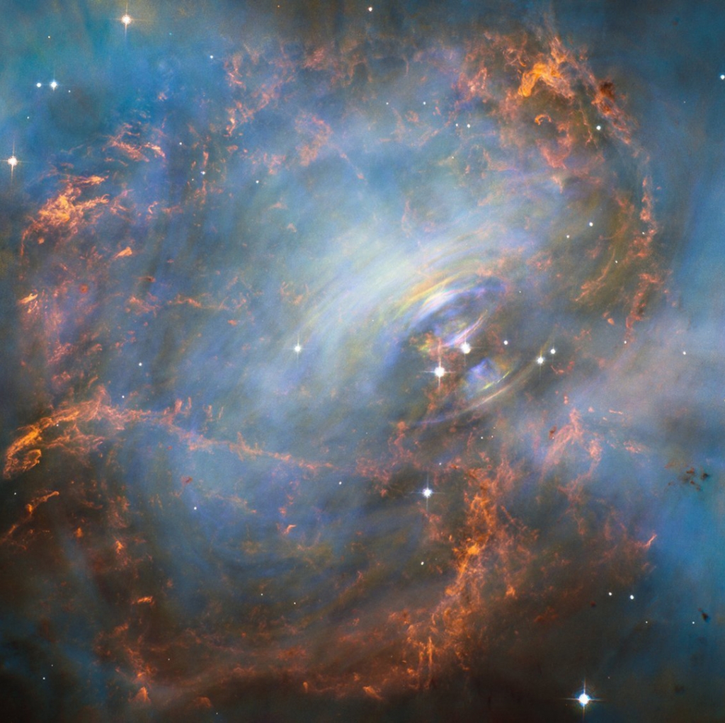 NASA's Hubble Space Telescope captured this image of the Crab Nebula and its'beating heart' which is a neutron star at the right of the two bright stars in the center of this image. The neutron star pulses 30 times a second. The rainbow colors are visib