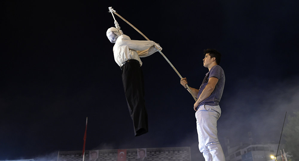 A Pro Erdogan supporter holds an effigy of US based cleric Fetullah Gulen hanged by a noosed on during a rally at Taksim square in Istanbul