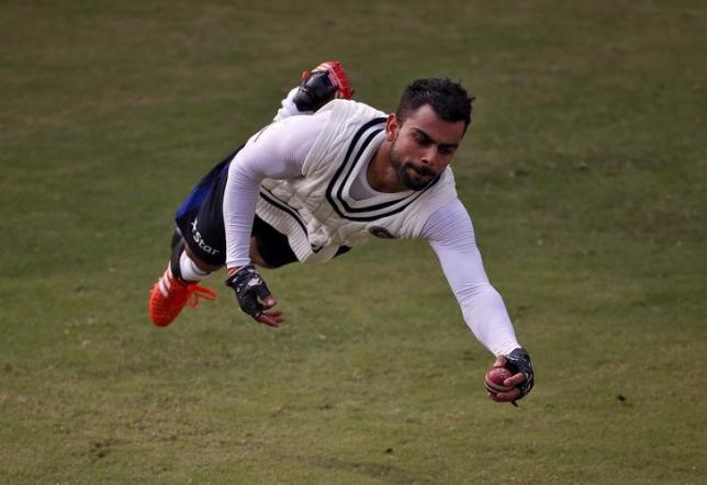 India's captain Virat Kohli dives to catch the ball during a practice session ahead of their fourth and final test cricket match against South Africa in New Delhi India