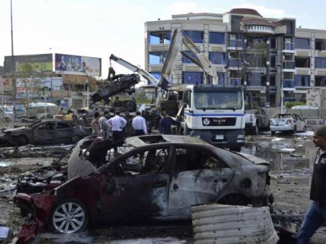 Iraqi security forces and civilians gather at the site of a car bomb attack in Baghdad