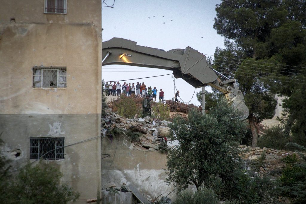 An Israeli excavator demolishes a house where Hamas fighter Mohammad al-Fakih who murdered Rabbi Miki Mark in a terror attack a few weeks ago was shot dead by Israeli troops during a raid in the West Bank village of Surif near Hebron