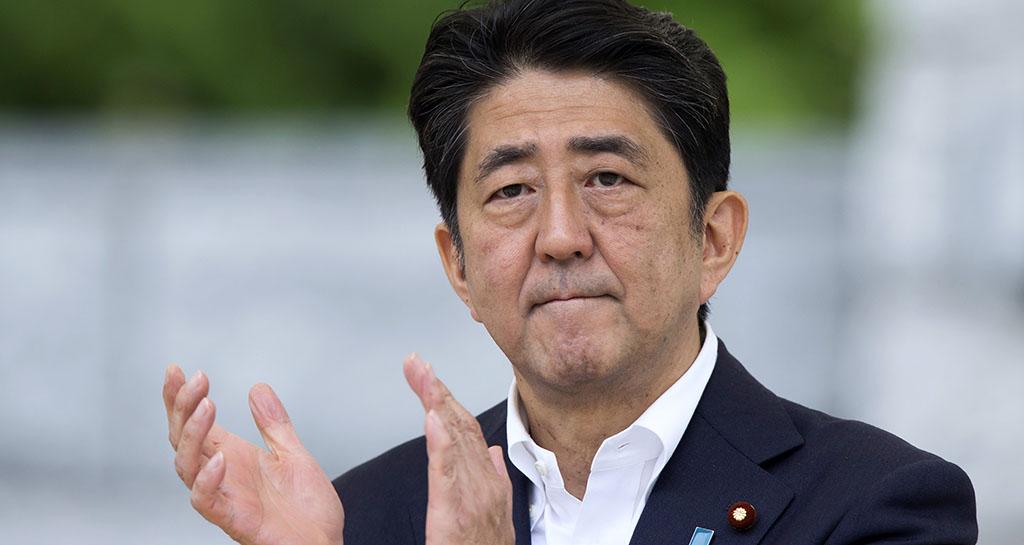 Japanese Prime Minister Shinzo Abe adjusts his necktie during the Asia Europe Meeting in Ulaanbaatar Mongolia on Saturday