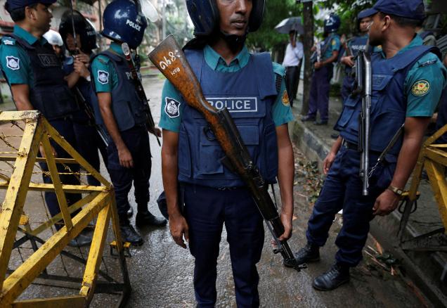 Policemen stand guard along a road leading to the Holey Artisan Bakery and the O'Kitchen Restaurant after gunmen attacked in Dhaka Bangladesh